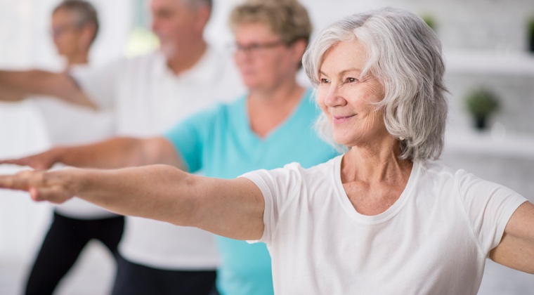 a woman doing tai chi with a group of people